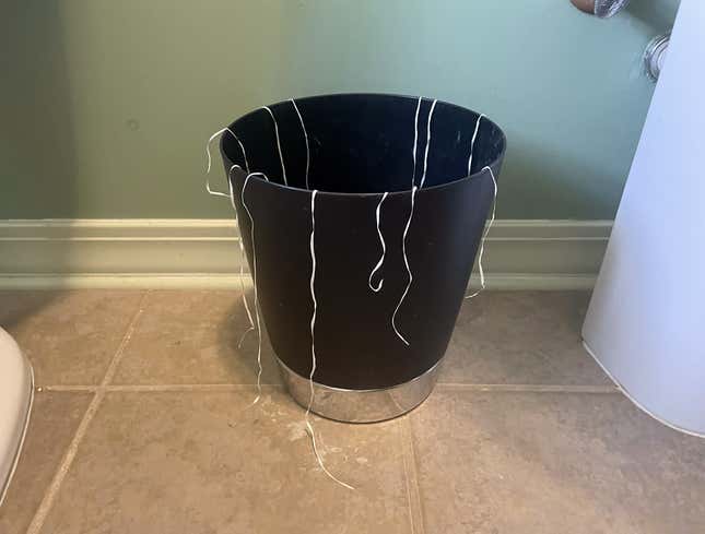 Image for article titled Floss Draped Around Top Of Bathroom Trash Bin Like Tinsel